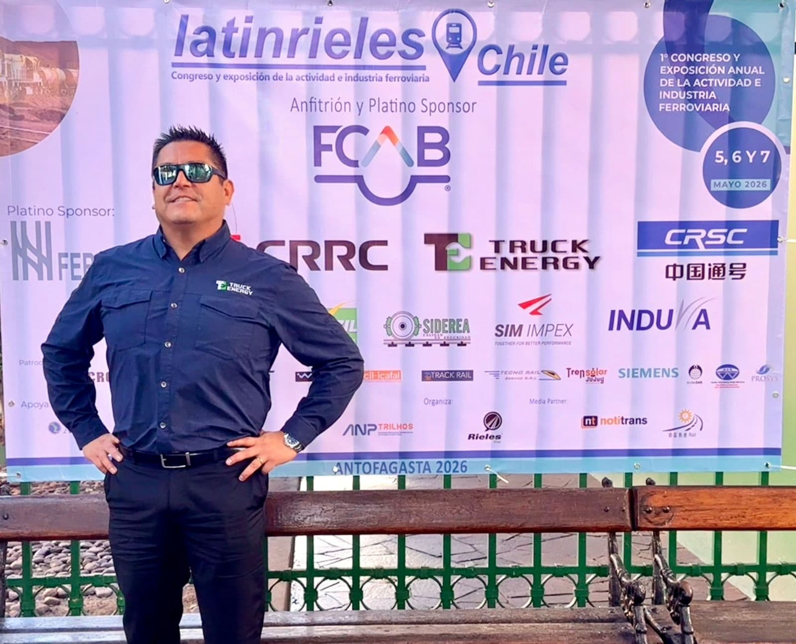 Un representante de Truck Energy de pie frente al pendón de Latinrieles Chile en Antofagasta, donde la marca aparece entre los patrocinadores del congreso