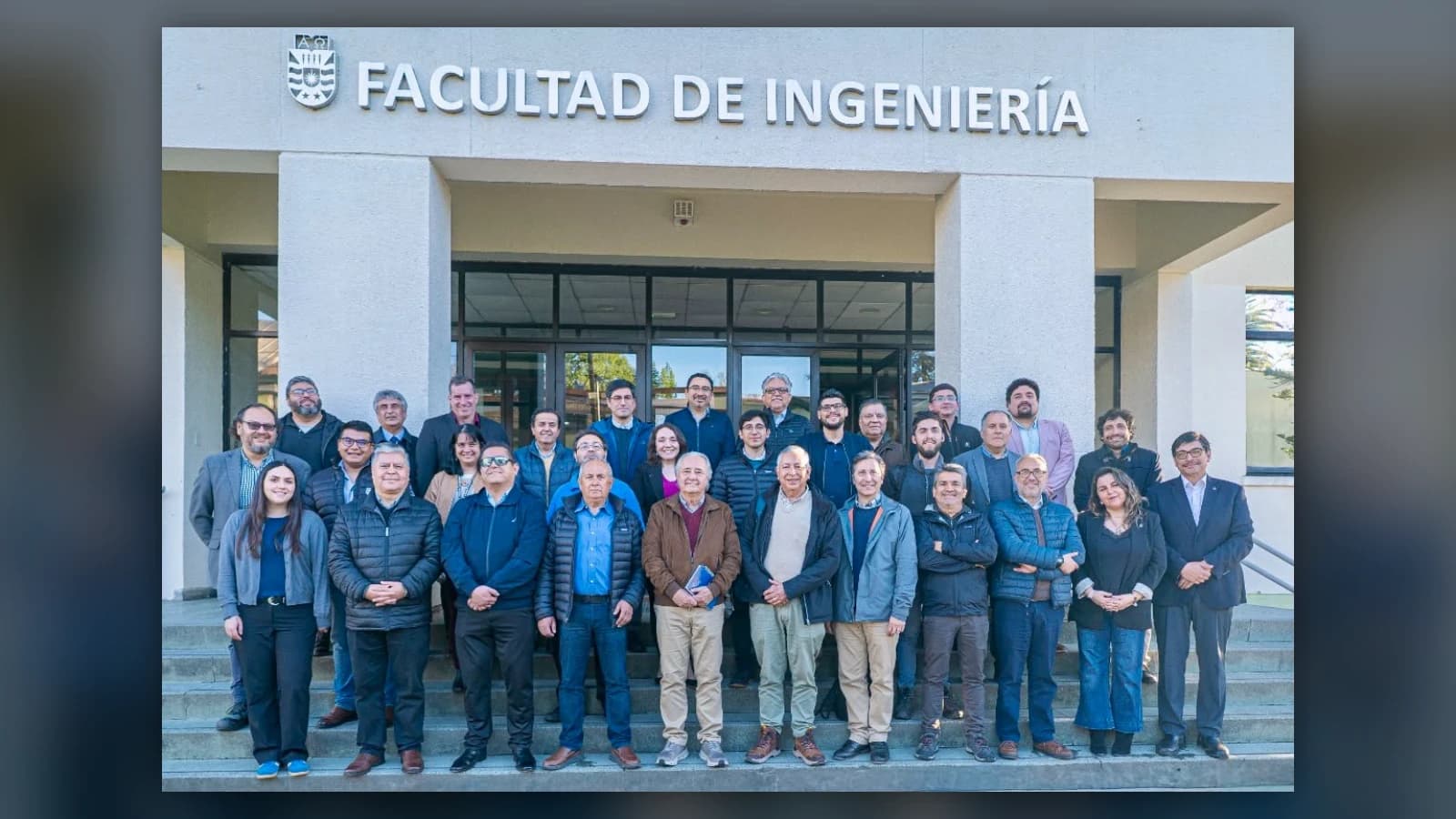 Fotografía grupal de más de treinta personas, entre académicos y representantes de empresas, de pie en la escalinata de acceso de la Facultad de Ingeniería de la Universidad del Bío-Bío, bajo el letrero y el escudo de la universidad
