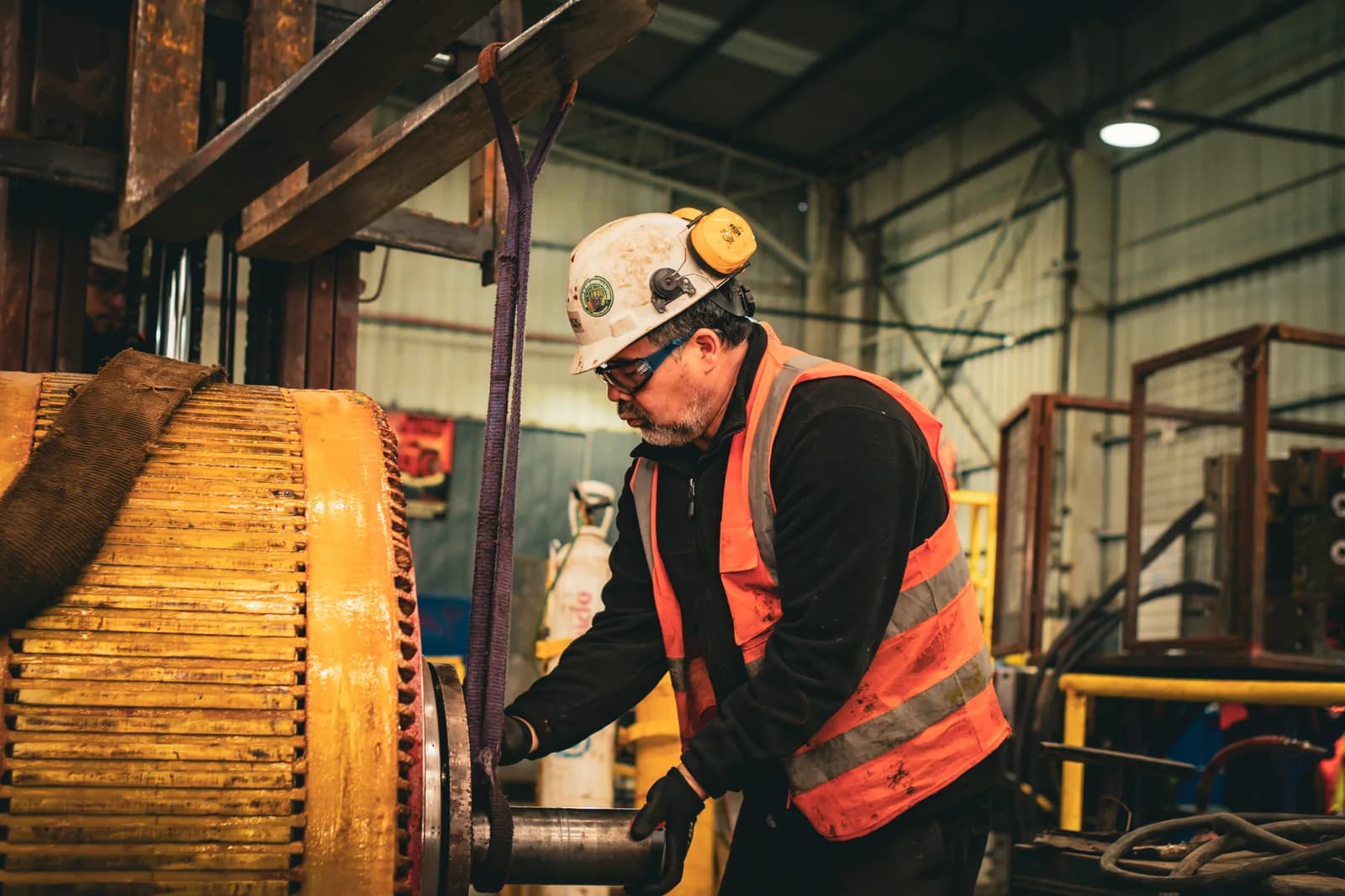 Technician beside the copper winding of a rotating electrical machine mounted in the Truck Energy workshop