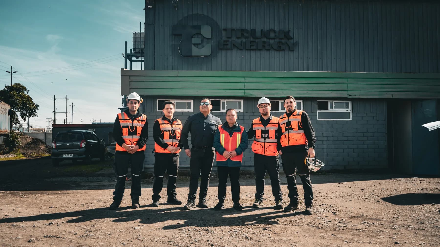 Equipo de Truck Energy junto al ingeniero visitante, de pie frente a la casa matriz de Coronel al terminar la capacitación