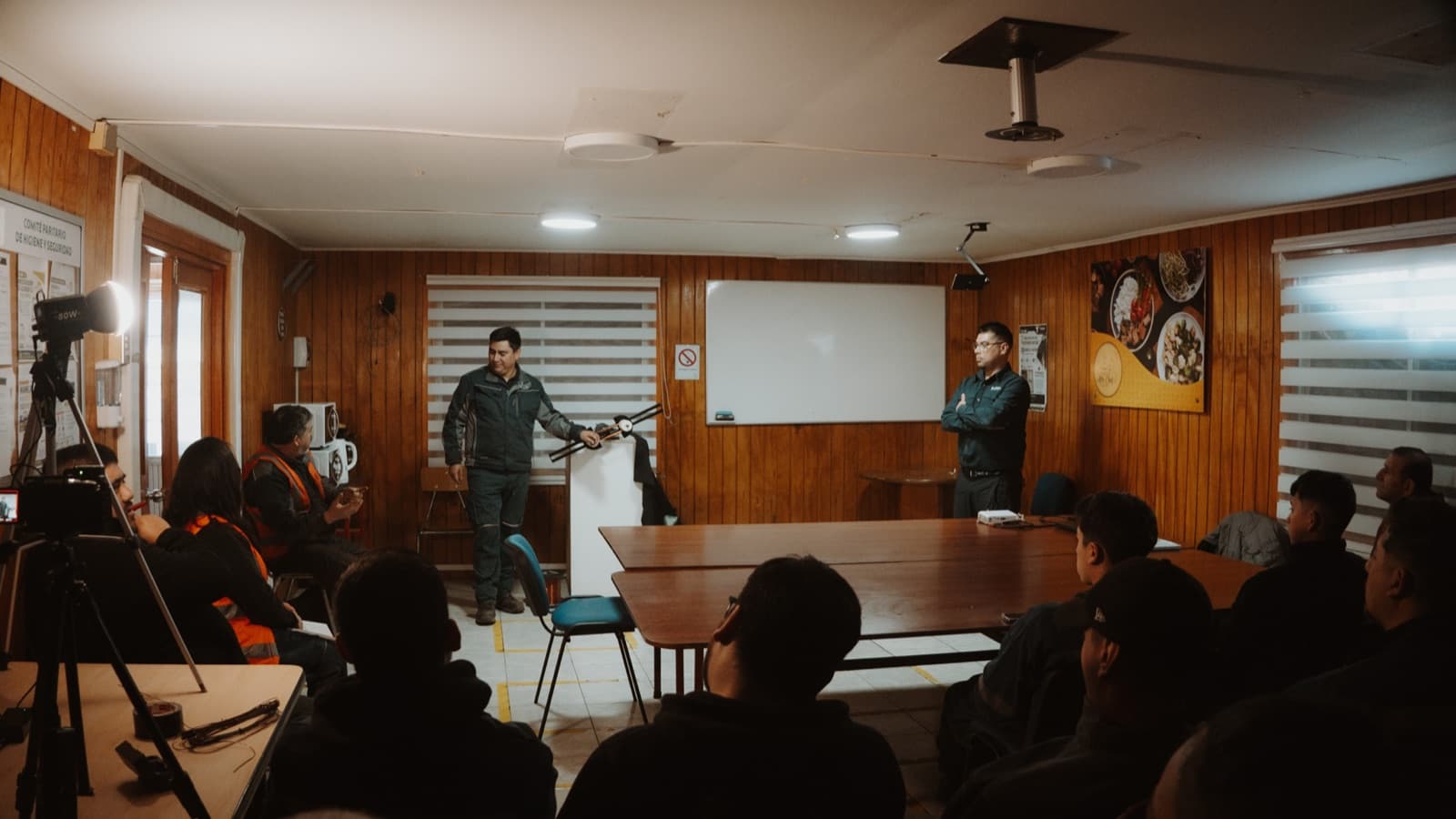 La sala vista desde atrás, con el trípode y la cámara que registran la charla en primer plano