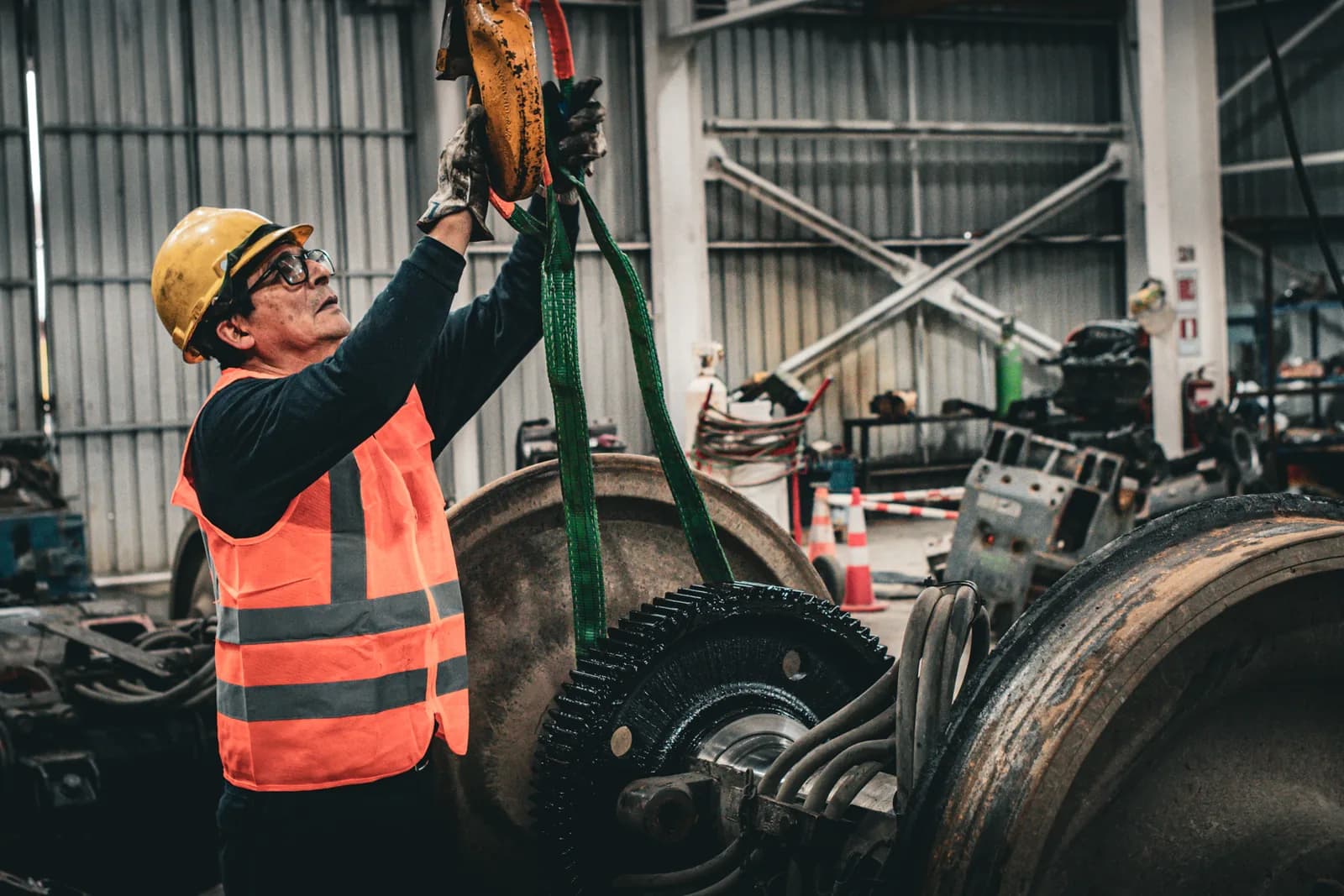 Worker hooking the sling onto the hoist above a wheelset assembly in the Coronel workshop